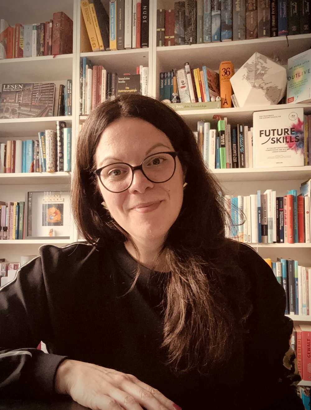 Sabrina Schell in front of her bookshelf